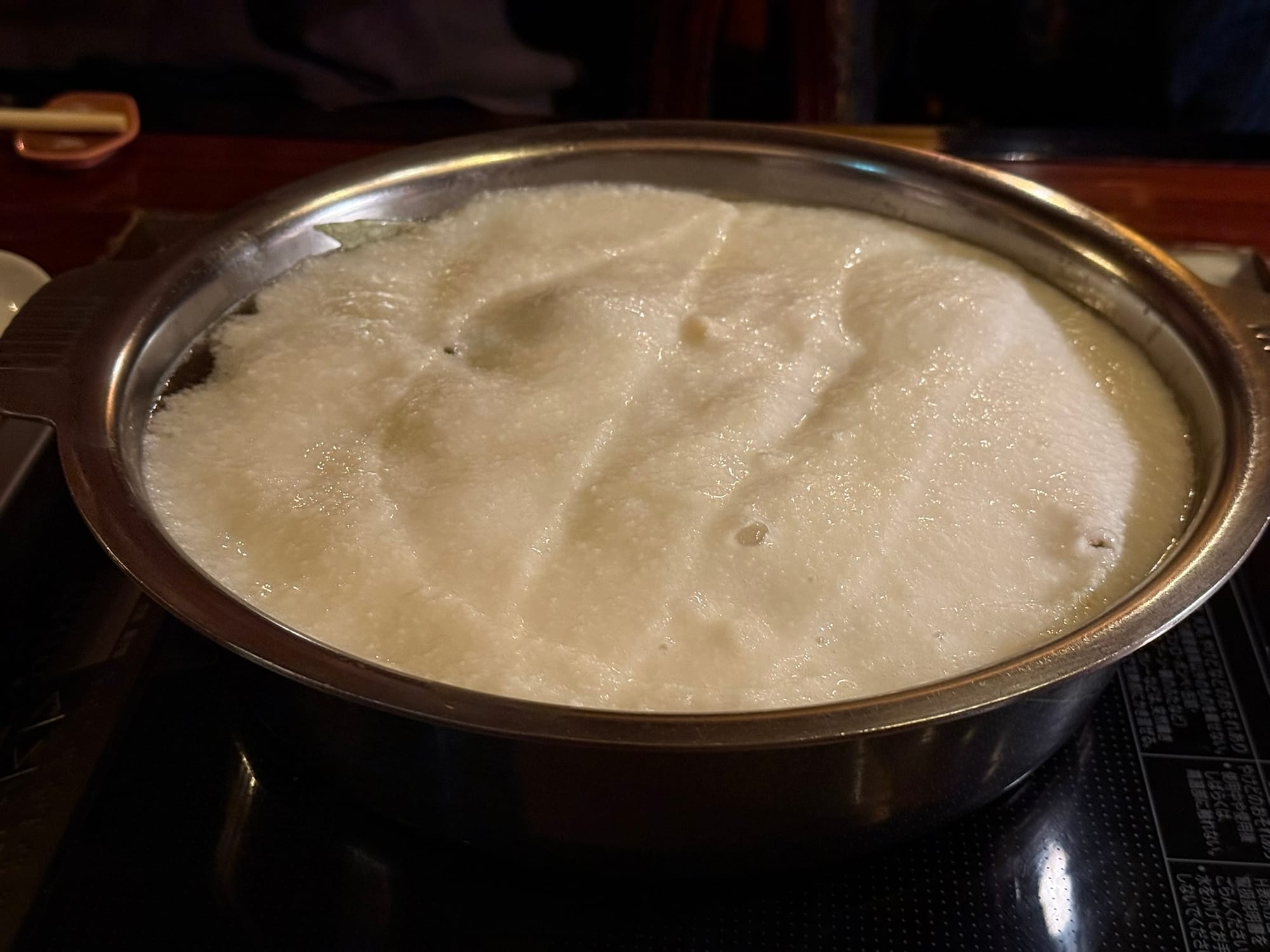 坐離宮的招牌畫面，店員將大量的純白山藥泥豪邁地鋪滿整個火鍋表面，帶來強烈的視覺震撼效果。