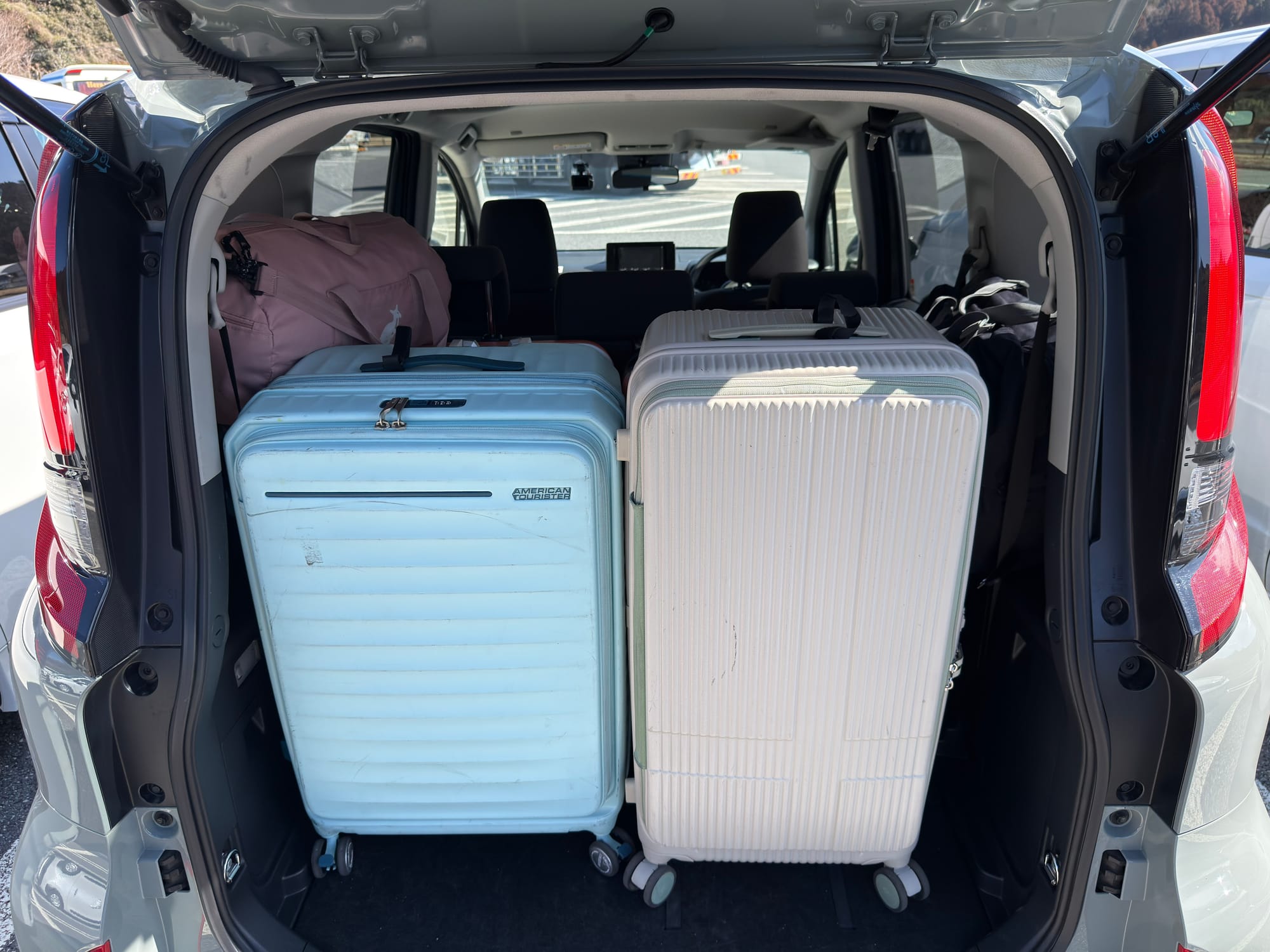 日本九州自駕租車 Toyota Sienta 行李空間實測：第三排收起後，可直立放入 2 個 28 吋與 2 個 26 吋大行李箱，兩側還能塞入 2 個手提行李袋。